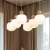 Lampadari Moderni-Selezionato da Mazzolaluce Lampadario in legno e vetro per soggiorno moderno con pendenti a sospensione